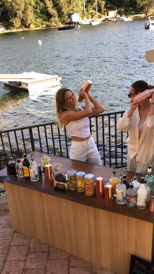 Two guests shaking their own cocktails at a class