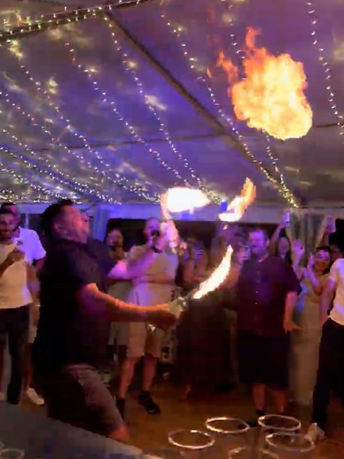 Three performers holding lit torches up in formation